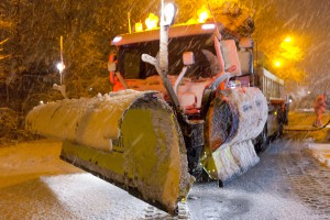 Voorzijde van strooiploeg aan vrachtwagen in de sneeuw